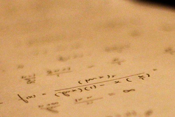 Written math equations on a piece of paper